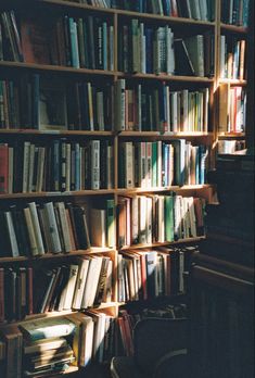 a bookshelf filled with lots of books next to a wall full of books