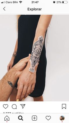 two people holding each other's hands with tattoos on their arms and arm,