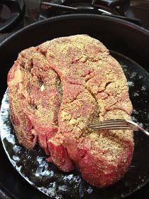 a piece of meat is being cooked in a skillet on the stove with a fork