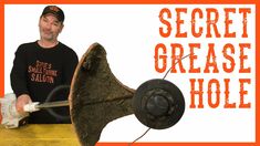 a man holding a large metal object with the words secret grease hole in front of him