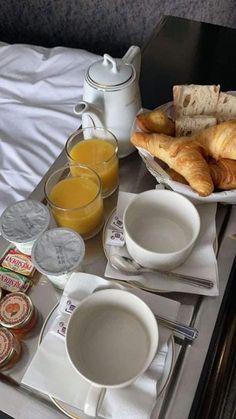 breakfast is served on the bed with orange juice, croissants and bread