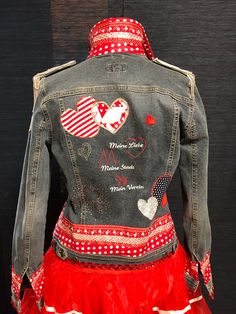 the back of a jean jacket with hearts on it and red ruffled skirt underneath