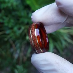 "☉ Cocobolo and Itin exotic south american tropical wood ring with a centered band of crushed Goldstone and Bronze inlays. The Stone has a glimmering like effect with small gold stars, a sparkly one of a kind stone. ☉ * Made to order in all sizes. * Finished with multiple layers of CA achieving a strong high-gloss polish * Extremely durable and water resistant. *Shipping* This item includes free domestic and international shipping. Its delivery process takes from 15 to 20 business days and it do Red Inlay Rings For Gifts, Brown Rings With Polished Finish For Gift, Brown Ring With Polished Finish For Gift, Brown Polished Finish Ring As Gift, Chakra Ring, Red Goldstone, Sandstone Ring, Sunstone Ring, Wedding Band Engagement Ring