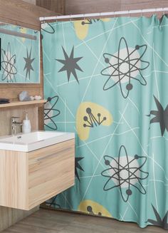 a bathroom with a shower curtain, sink and mirror in it that has an atomic symbol on it