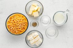 ingredients to make corn and cheese soup laid out on a white surface, including milk