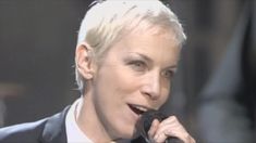 a woman with blonde hair is singing into a microphone