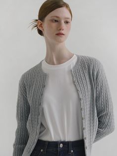 a woman in white shirt and grey cardigan