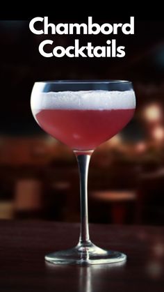 a close up of a wine glass on a table with the words champagne cocktails