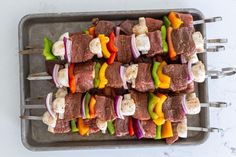 skewered meat and vegetables on a tray ready to be cooked in the oven