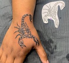 a person's hand with a scorpion tattoo on it