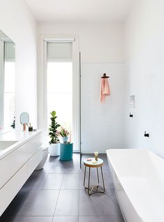 an image of a bathroom with white walls and black tile flooring on the phone