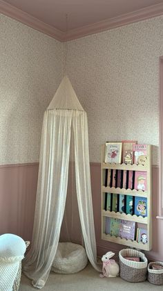 a white canopy bed sitting next to a book shelf