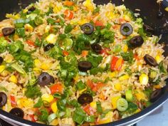 a pan filled with rice and vegetables on top of a stove