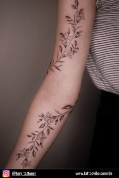 a woman's arm with flowers and leaves tattooed on the left side of her arm