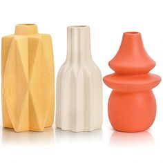 three different colored vases sitting next to each other