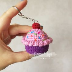 a small crocheted cupcake keychain is being held by a hand