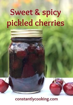 a jar filled with cherries sitting on top of a table