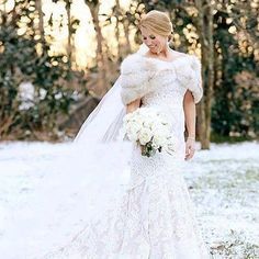 a woman in a wedding dress standing in the snow