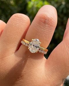 a woman's hand with a yellow and white diamond ring on her left finger