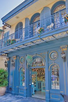 an ornate building with blue doors and balconys on the second floor is decorated with flowers