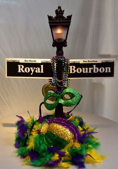 a mardi gras decoration with a street sign in the background that says royal bourbon