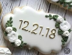 decorated cookies with the number twenty twelve and flowers on them are displayed for guests to eat