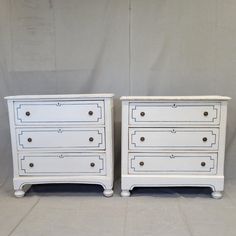 two white dressers sitting next to each other