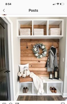 the entryway is decorated in white and wood with baskets, wreaths and shoes