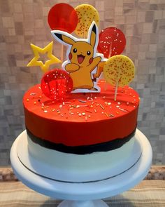 a pokemon themed birthday cake with sprinkles and stars on top, sitting on a pedestal