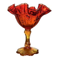 an orange glass vase sitting on top of a table