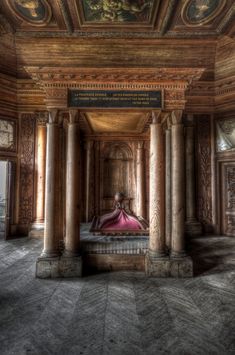 an ornate room with columns and paintings on the walls