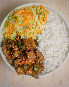 a white plate topped with rice and meat