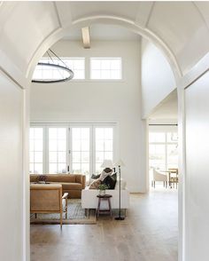 an open living room with white walls and wood flooring is seen from the doorway