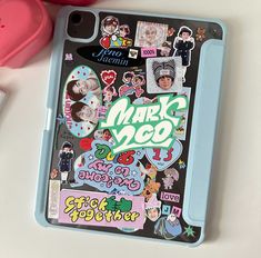 an ipad case with many stickers on it next to a pink heart shaped object