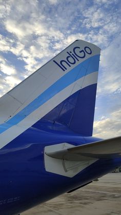 the tail end of an airplane that is blue and white with words indigo on it