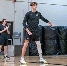 two men in black shirts and white socks playing basketball