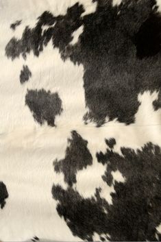 the black and white cow print is on top of an animal skin material that looks like it has spots