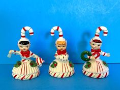 three ceramic figurines with candy canes on them