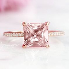 an engagement ring with a pink diamond in the center and white diamonds on the sides