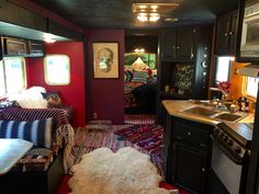 the kitchen and living room are decorated in black, red, and white colors with an area rug on the floor