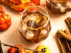 an assortment of fruits and vegetables on a table with ice cubes, cinnamon sticks, and apples