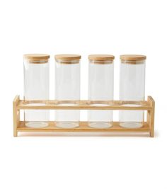 four glass jars with wooden stand on white background