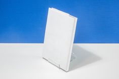 an open white box sitting on top of a table next to a blue and white wall