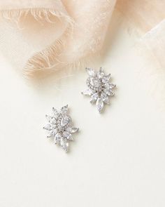 TALLULAH CZ CLUSTER STUDS (JE-4201)Steal the spotlight in our Tallulah CZ Cluster Studs. Ultra modern with no shortage of sparkle, Tallulah is crafted with a teardrop cubic zirconia in a delicate halo setting surrounded by glittering marquise cubic zirconias. These earrings will become your everyday go-to long after your wedding day.DETAILS• Designed with cubic zirconias.• Measures .75 x .5 inches.• Finishes: silver & rose gold.• Lightweight for easy day to night wear.• Hypoallergenic, lead- Gold Bridal Hair Accessories, Pearl Bridesmaid Jewelry, Wedding Jewelery, Bridal Earrings Studs, Silver Bridal Earrings, Bridal Statement Earrings, Bride Jewelry Set, Wedding Day Details, Statement Hoop Earrings