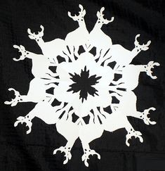 a white snowflake on a black background that looks like an ornament