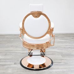 a white and gold chair sitting on top of a wooden floor