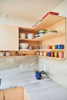 the shelves in the kitchen are filled with dishes