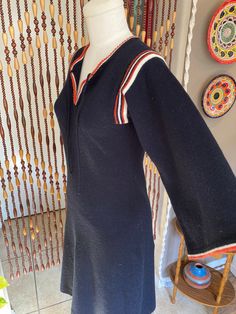 Adorable 70's knit mini dress with bell sleeves and center neck ties with orange and white striped detail. This dress is in excellent vintage condition, no holes or stains noted. There is no size tag so please see measurements. modern size is medium. Bust 34-38 in  Waist 32-36 in  Hips 42-46 Length (from shoulder to hem) 41 in 70’s Dresses, 70's Dress, Boho Knit, Dress With Bell Sleeves, Groovy 70s, 70s Dress, Mod Dress, Neck Ties, Knit Mini Dress