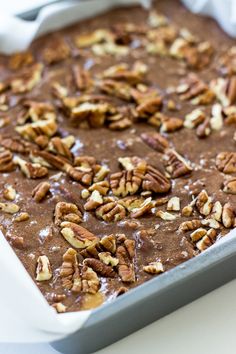 a pan filled with chocolate and nuts on top of a table