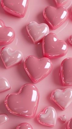 many pink heart shaped candies on a pink surface